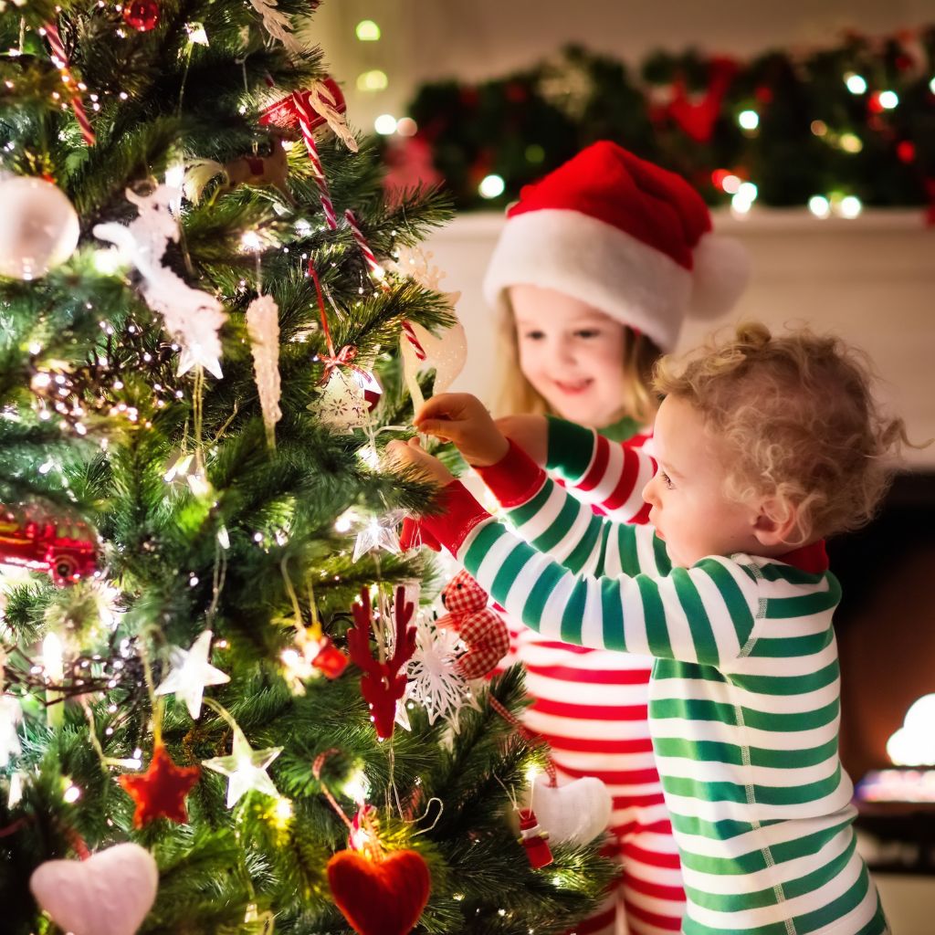 Family Holiday Tradition of children hanging ornaments on the tree.